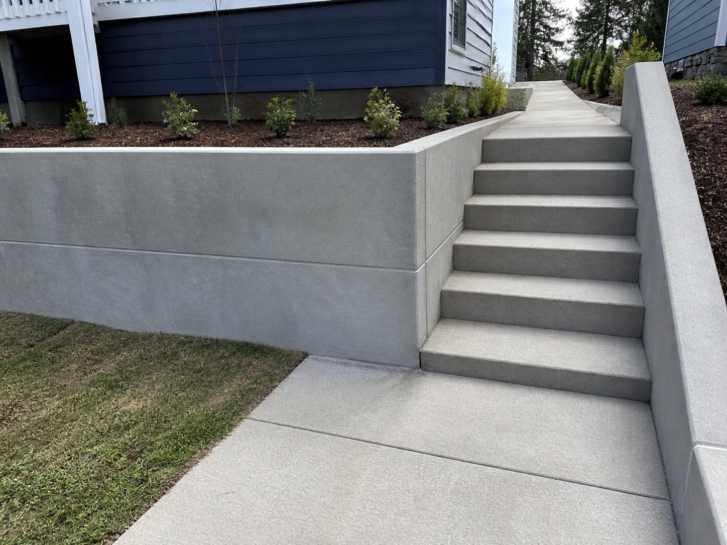 Beautiful concrete retaining wall with integrated steps at a residential property